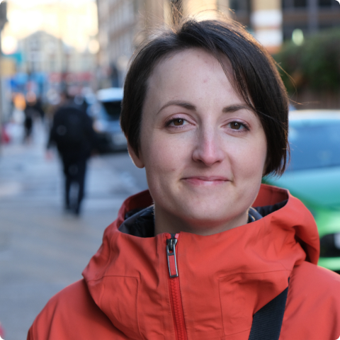 satisfied looking product designer wearing a delightful red jacket